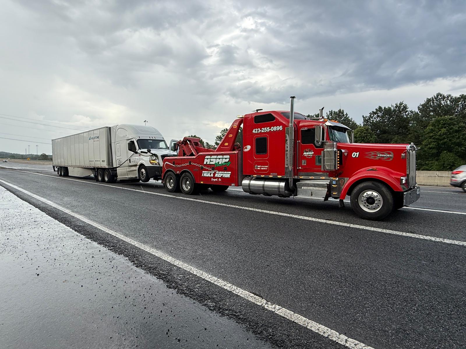 Flatbed tow truck on a 24/7 roadside call at night, Chattanooga area